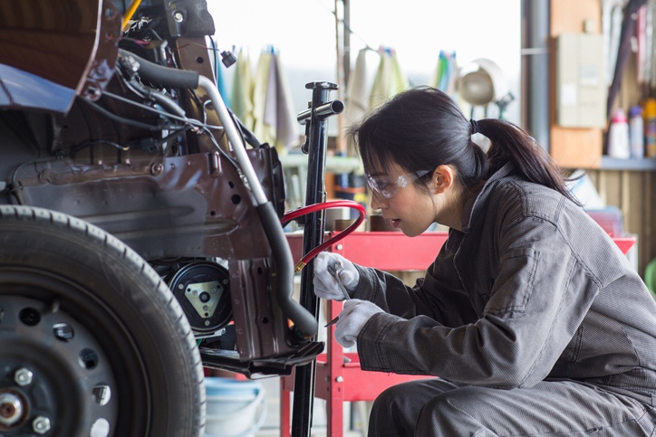 mechanik naprawiający uszkodzony samochód